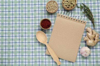 Photo of Blank recipe book and different ingredients on checkered tablecloth, flat lay. Space for text
