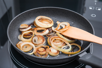 Cooking onion rings in frying pan, closeup