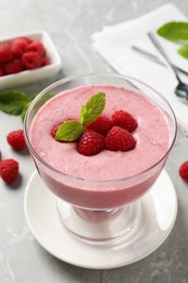 Delicious raspberry mousse with mint on grey marble table