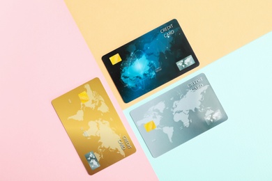 Different plastic credit cards on color background, flat lay