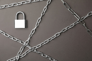 Steel padlock and chains on grey background, flat lay. Safety concept