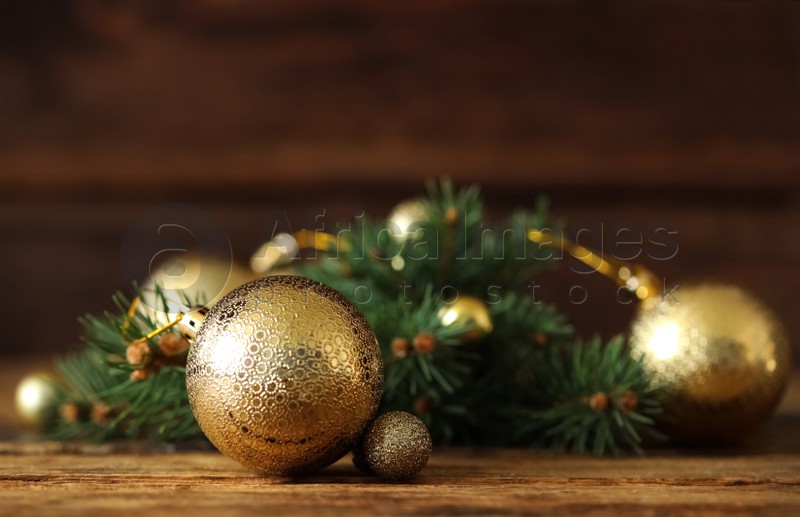 Beautiful Christmas balls and fir branch on wooden table. Space for text