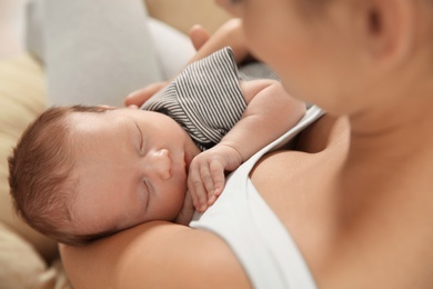 Young woman holding her newborn baby, closeup