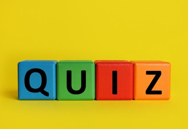 Colorful cubes with word Quiz on yellow background. Space for text
