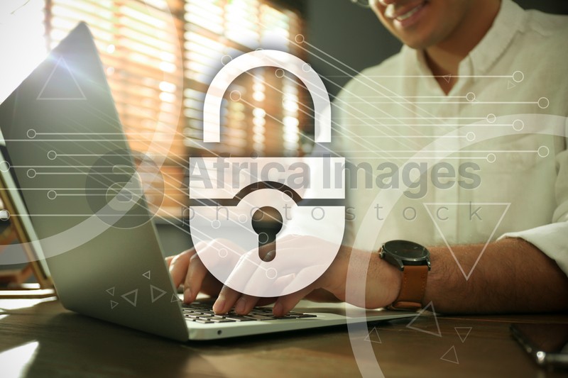 Cyber security concept. Illustration of lock and man working with laptop at wooden table, closeup