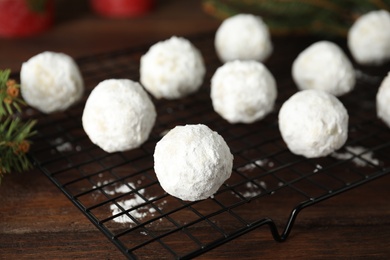 Tasty snowball cookies on cooling rack, closeup. Christmas treat