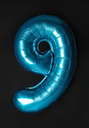Photo of Blue number nine balloon on black background