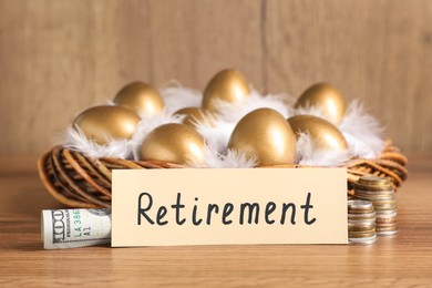 Golden eggs in nest, money and card with word Retirement on wooden table. Pension concept