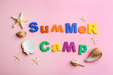 Flat lay composition with phrase SUMMER CAMP made of magnet letters on pink background