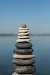 Stack of stones near sea on sunny day. Harmony and balance concept
