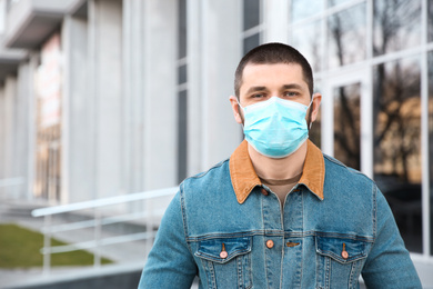 Photo of Man wearing disposable mask outdoors. Dangerous virus