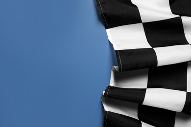 Checkered finish flag on blue background, top view. Space for text