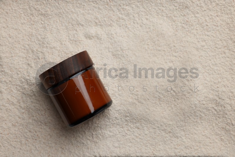 Photo of Glass jar on powder, top view. Space for text