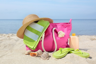 Photo of Set of different stylish beach accessories on sand