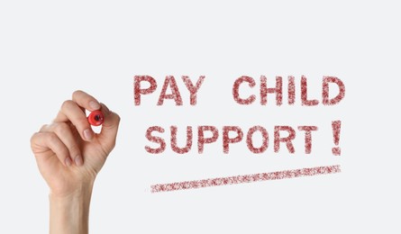 Woman with marker and phrase PAY CHILD SUPPORT! on white background, closeup