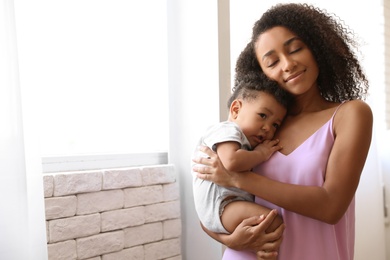 African-American woman with her baby at home. Happiness of motherhood