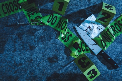 Photo of Flat lay composition with evidences and crime scene markers on stone background at night