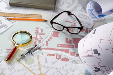 Office stationery and eyeglasses on cadastral map of territory with buildings