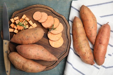 Sweet potatoes and knife on light blue wooden table, flat lay