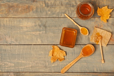 Photo of Flat lay composition with honey on wooden background. Space for text