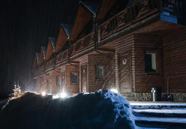 Wooden hotel on snowy evening. Winter vacation