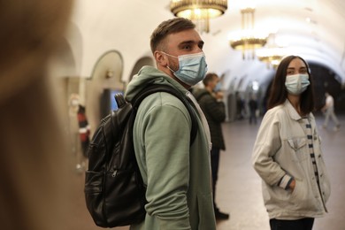 People in protective masks at subway station. Public transport
