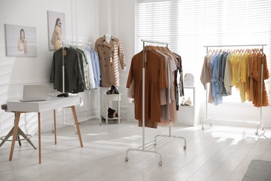 Photo of Modern boutique interior with stylish clothes and laptop