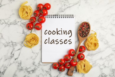 Notebook with inscription Cooking Classes, raw pasta, tomatoes and spices on white marble table, flat lay