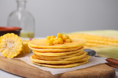 Stack of tasty corn pancakes with sweet kernels served on table, closeup