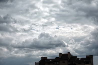 View of buildings under sky with heavy rainy clouds