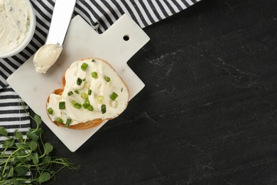 Photo of Delicious sandwich with cream cheese and chives on black table, flat lay. Space for text