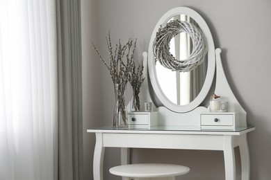Elegant dressing table decorated with pussy willow branches indoors