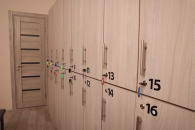 Many numbered wooden lockers with keys indoors