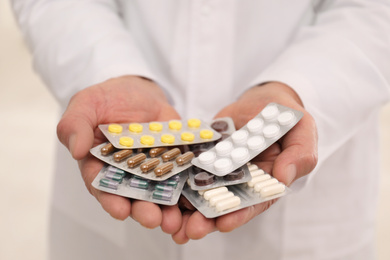 Senior pharmacist with handful of pills, closeup