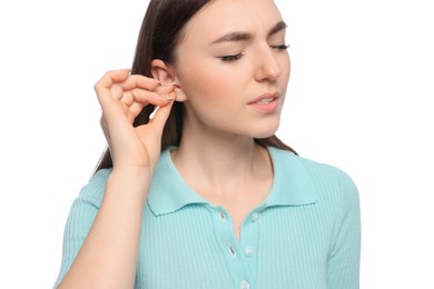 Young woman cleaning ear with cotton swab on white background, closeup