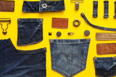 Photo of Flat lay composition with garment accessories and cutting details for jeans on yellow background