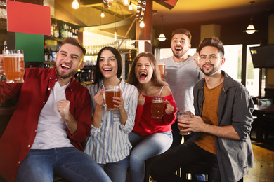 Group of friends watching football in sport bar