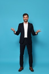 Photo of Happy bearded man in suit on light blue background