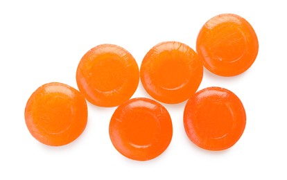 Many orange cough drops on white background, top view