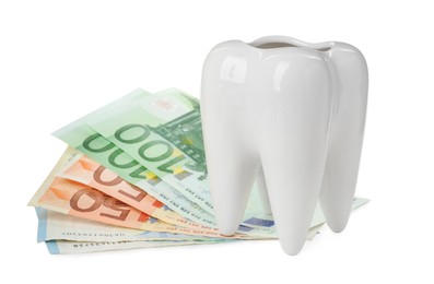 Ceramic model of tooth and euro banknotes on white background. Expensive treatment