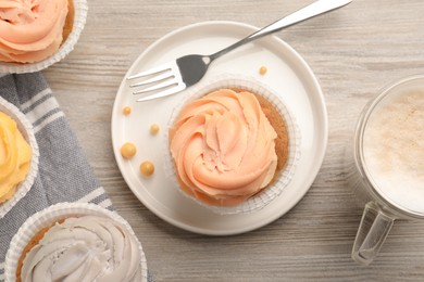 Tasty cupcakes served on wooden table, flat lay