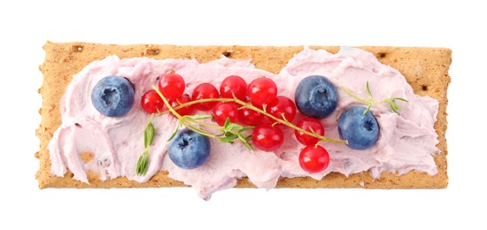 Photo of Tasty crispy cracker with cream cheese, thyme and berries isolated on white, top view