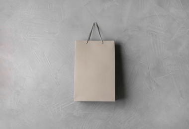 Paper shopping bag hanging on grey wall