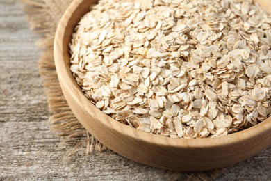 Bowl with oatmeal on wooden table, closeup
