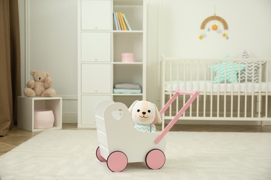 Toy walker with soft dog in baby room. Interior design