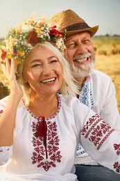Happy mature couple wearing Ukrainian national clothes in field