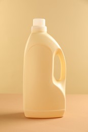 Photo of Bottle with detergent on beige background. Cleaning supply