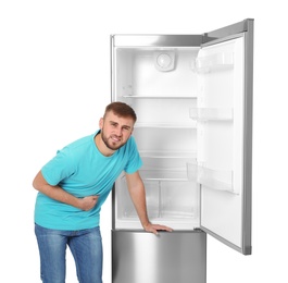 Hungry man near empty refrigerator on white background