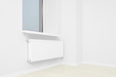 Photo of New empty office room with white walls, radiator and clean window. Interior design