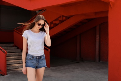 Young woman wearing gray t-shirt on street. Urban style